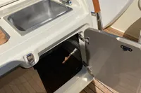 2023 Invictus GT280 boat kitchenette with sink and open storage on teak deck.