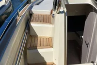 2023 Invictus GT280 yacht with teak steps and open cabin entrance.