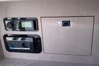 Control panel and storage compartment in 2023 Invictus GT280 boat interior.