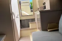 Interior of 2023 Invictus GT280 yacht, featuring modern seating and compact kitchen area.