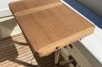 Luxury wooden table on 2023 Invictus GT280 boat deck, surrounded by cushioned seating.