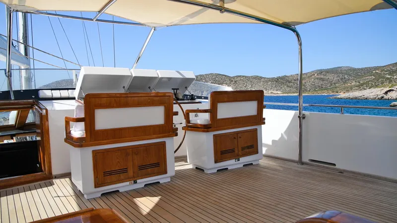 Tamarita Yacht Photos Pics Luxury yacht deck with wooden cabinetry, Perini Navi 46, 1992, overlooking serene blue waters.