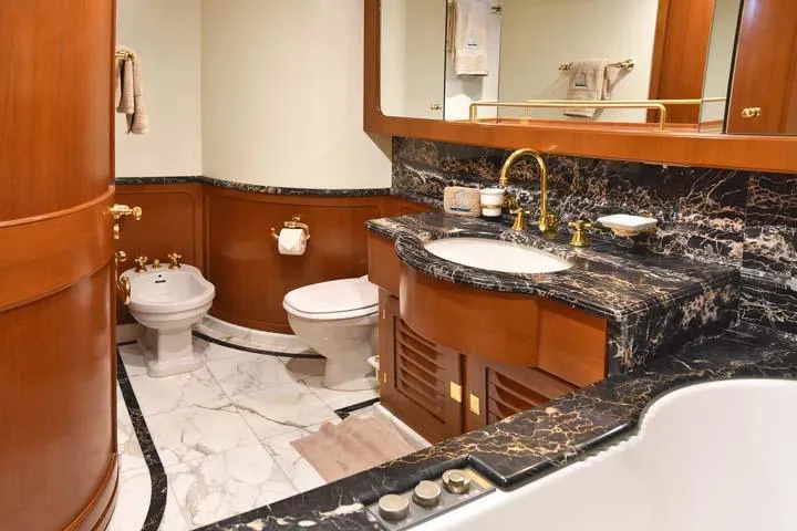 Tamarita Yacht Photos Pics Luxurious yacht bathroom with marble accents, gold fixtures, and wooden cabinetry, Perini Navi 46, 1992.