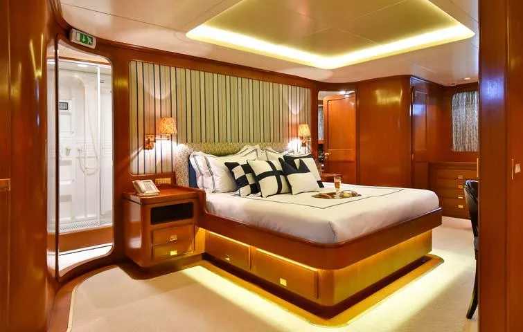 Tamarita Yacht Photos Pics Luxurious cabin interior of 1992 Perini Navi 46 yacht with elegant wood finishes and ambient lighting.