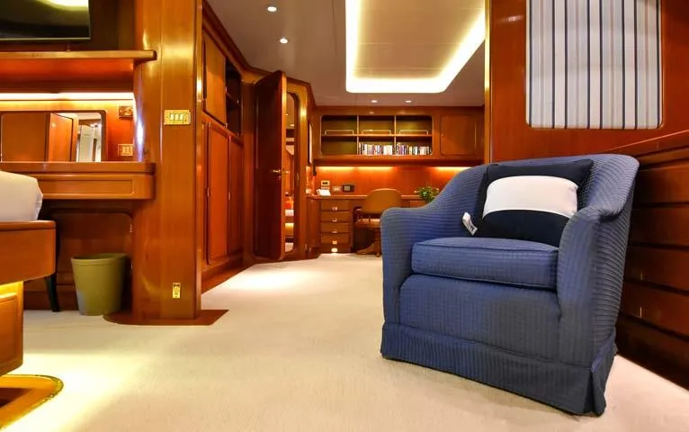 Tamarita Yacht Photos Pics Luxurious interior of 1992 Perini Navi 46 yacht with elegant wood finishes and cozy seating.