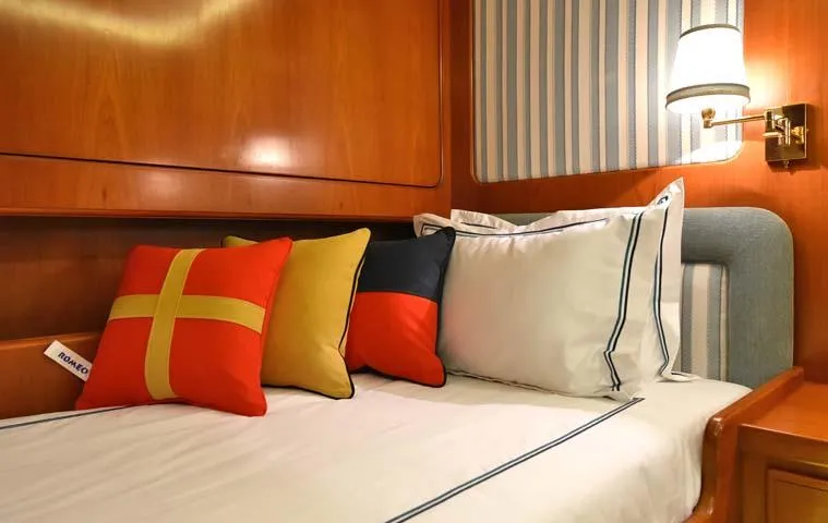 Tamarita Yacht Photos Pics Luxurious cabin interior of 1992 Perini Navi 46 yacht with colorful cushions and elegant bedding.