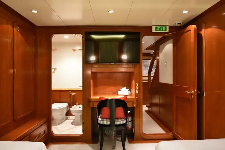 Tamarita Yacht Photos Pics Luxurious cabin interior of 1992 Perini Navi 46 yacht with wooden furnishings and modern amenities.