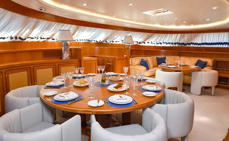 Tamarita Yacht Photos Pics Luxurious dining area on a 1992 Perini Navi 46 yacht, elegantly set table and plush seating.
