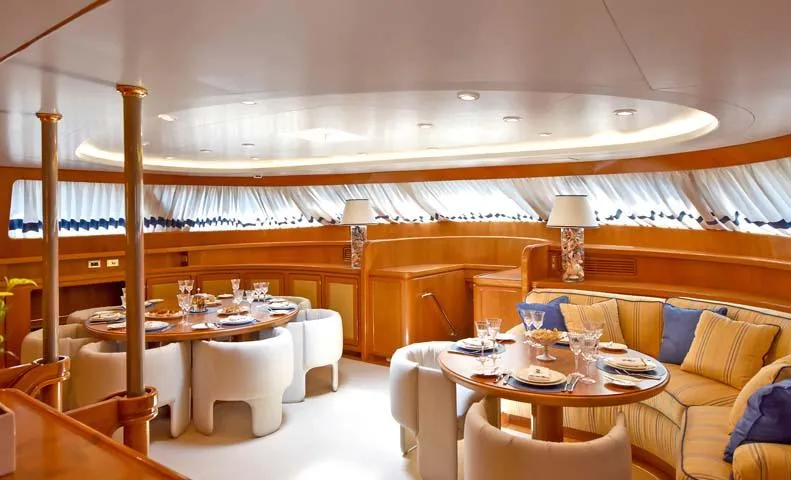Tamarita Yacht Photos Pics Luxurious interior of 1992 Perini Navi 46 yacht with elegant dining area and plush seating.