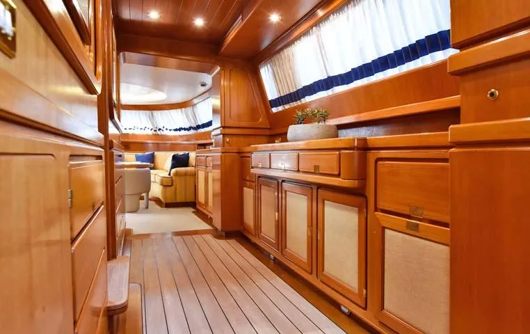 Tamarita Yacht Photos Pics Luxurious wooden interior of a 1992 Perini Navi 46 yacht, featuring elegant cabinetry and seating.