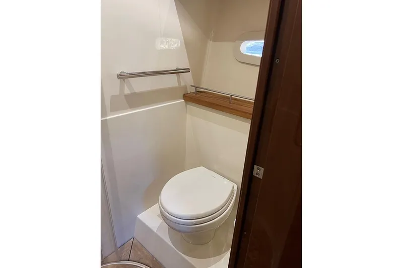  Yacht Photos Pics Bathroom interior of 2015 Sea Ray 470 Sundancer yacht, featuring a compact toilet and window.