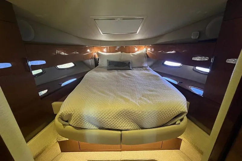  Yacht Photos Pics Luxurious cabin interior of 2015 Sea Ray 470 Sundancer yacht with cozy bed and ambient lighting.