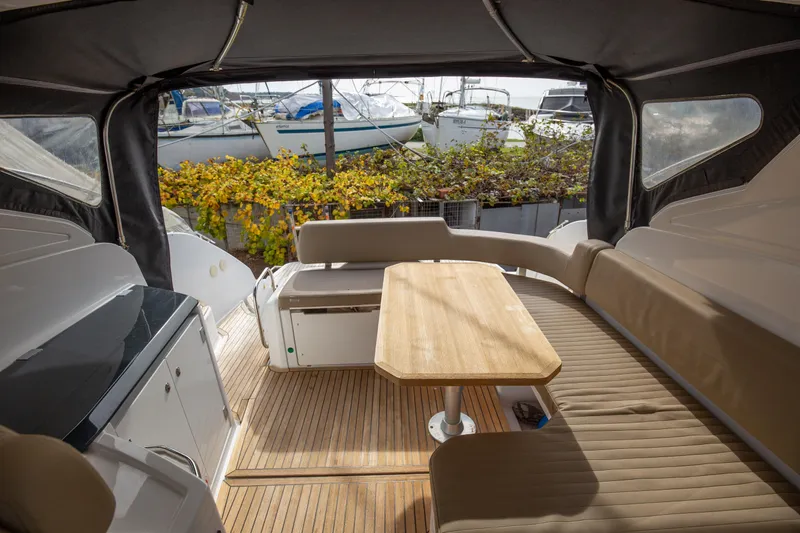  Yacht Photos Pics 2017 Azimut 34 yacht interior with seating and table, docked near other boats.