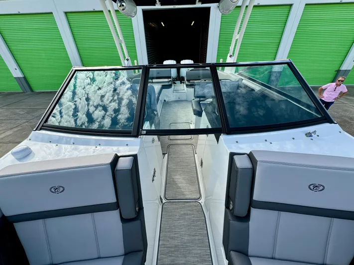  Yacht Photos Pics 2022 Cobalt R8 Outboard boat with sleek design, docked near green storage units.