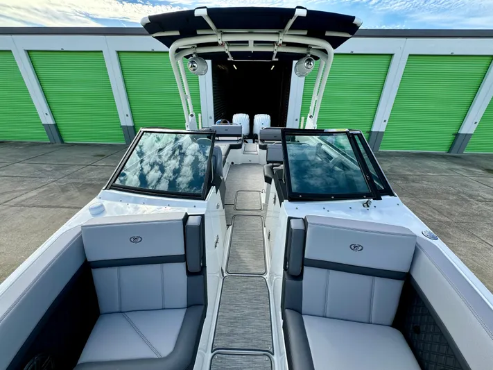  Yacht Photos Pics 2022 Cobalt R8 Outboard boat with sleek interior, parked near green storage units.