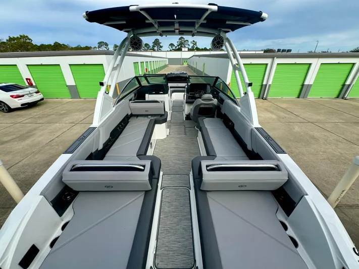  Yacht Photos Pics 2022 Cobalt R8 Outboard boat with spacious seating, docked near green storage units.