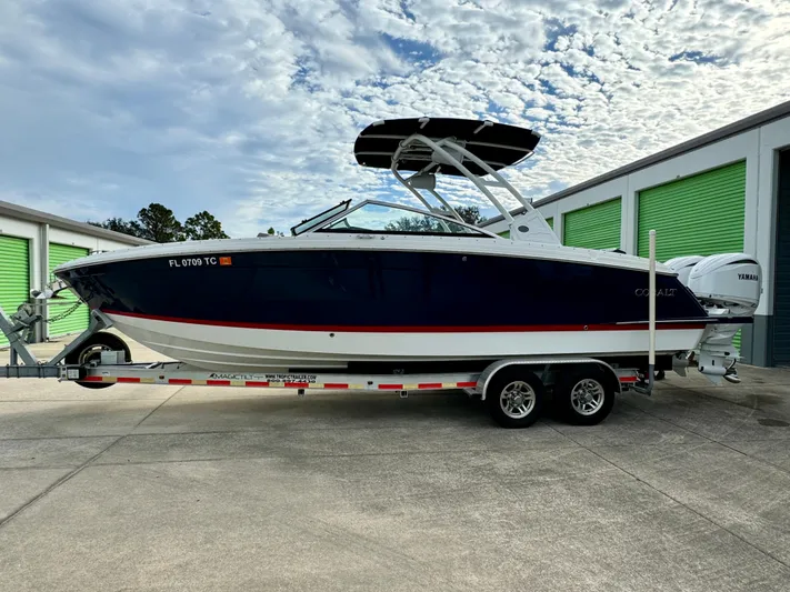  Yacht Photos Pics 2022 Cobalt R8 Outboard boat on trailer, parked near storage units.