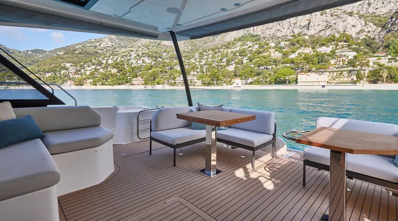  Yacht Photos Pics Luxurious 2025 Prestige M48 yacht deck with seating, overlooking scenic coastal landscape.