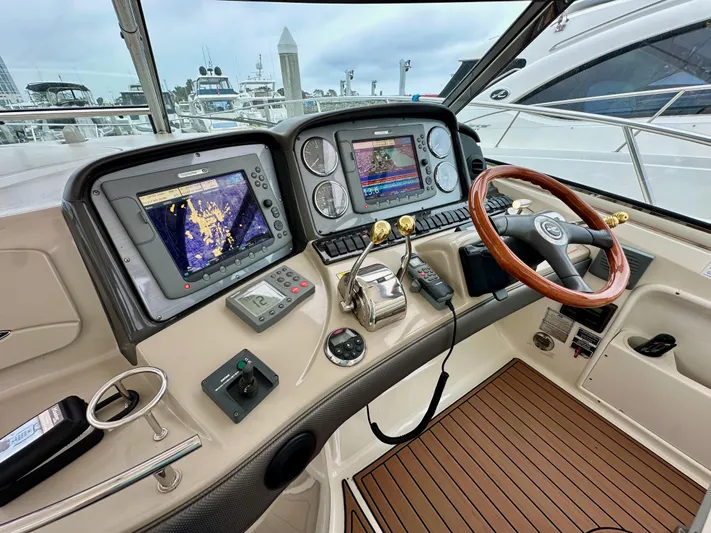 Aztec Princess Yacht Photos Pics Helm of 2006 Sea Ray 44 Sundancer with navigation screens and wooden steering wheel.