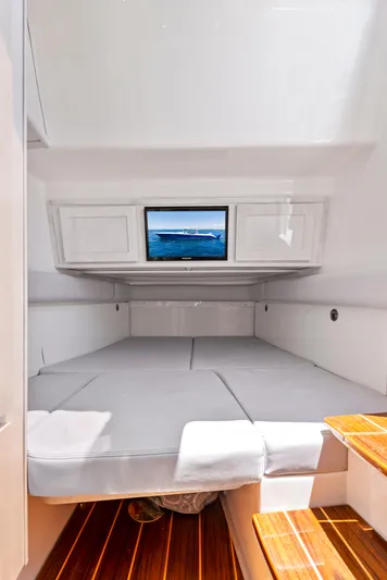 Strong III Yacht Photos Pics 2022 HCB Suenos cabin interior with bed, TV, and wooden steps.