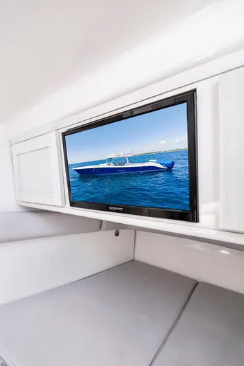 Strong III Yacht Photos Pics 2022 HCB Suenos boat interior with wall-mounted TV displaying a blue boat on the water.