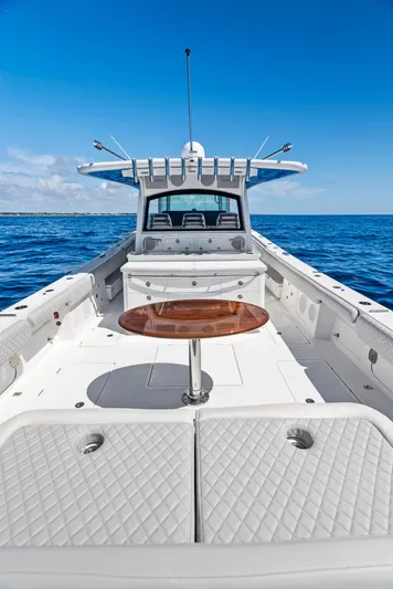 Strong III Yacht Photos Pics 2022 HCB Suenos boat on open sea, featuring luxurious seating and wooden table.