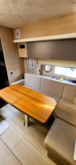  Yacht Photos Pics Interior of 2023 Cranchi Z35 yacht with wooden table and beige seating.