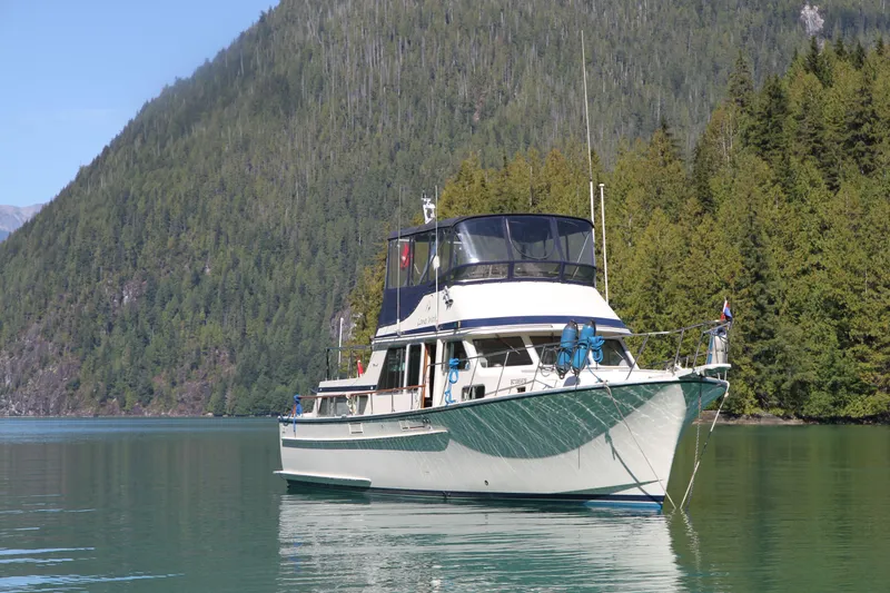 Lone Wolf Yacht Photos Pics 1983 Tolly 43 TriCabin Motor Yacht on serene lake with forested mountain backdrop.