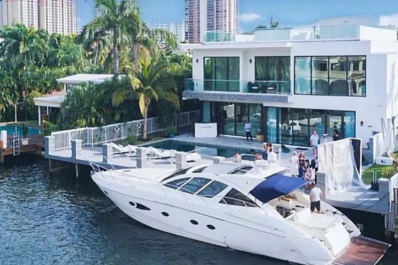 Sol Yacht Photos Pics Luxurious 2010 Azimut Atlantis 54 yacht docked by a modern waterfront villa.