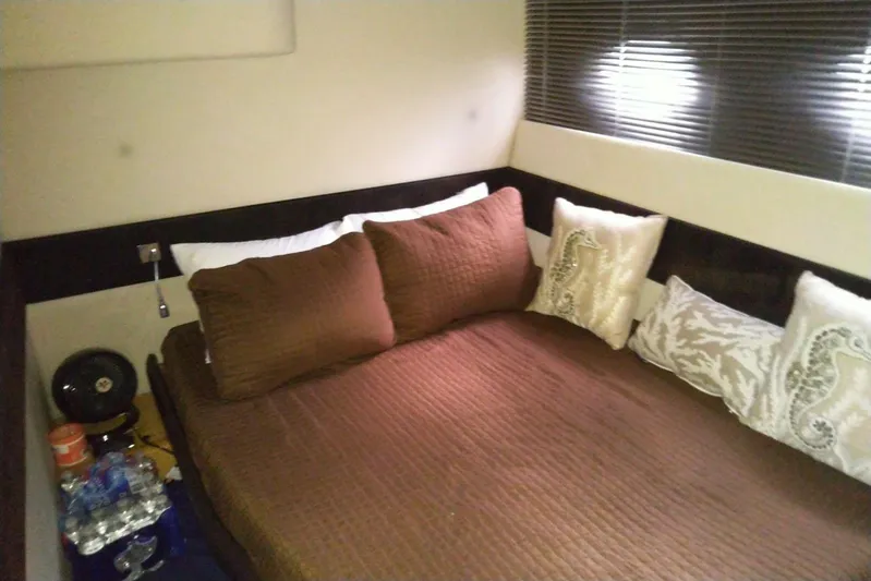 Sol Yacht Photos Pics Cozy bedroom interior of 2010 Azimut Atlantis 54 yacht with brown bedding and decorative pillows.