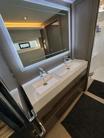 Hamlet Yacht Photos Pics Modern bathroom in 2023 Leopard 46PC yacht with dual sinks and illuminated mirror.