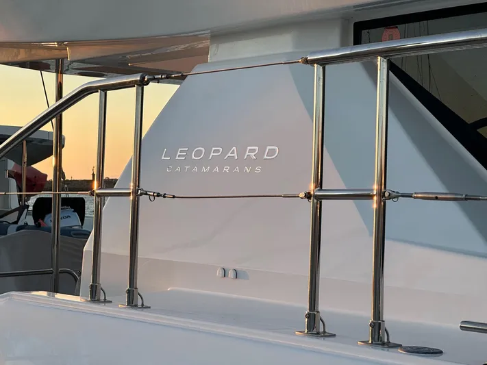 Hamlet Yacht Photos Pics 2023 Leopard 46PC catamaran with sleek design and stainless steel railings at sunset.