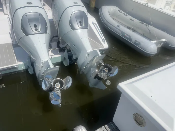  Yacht Photos Pics Twin outboard motors on a 2009 Venture 34 CC boat docked beside an inflatable dinghy.