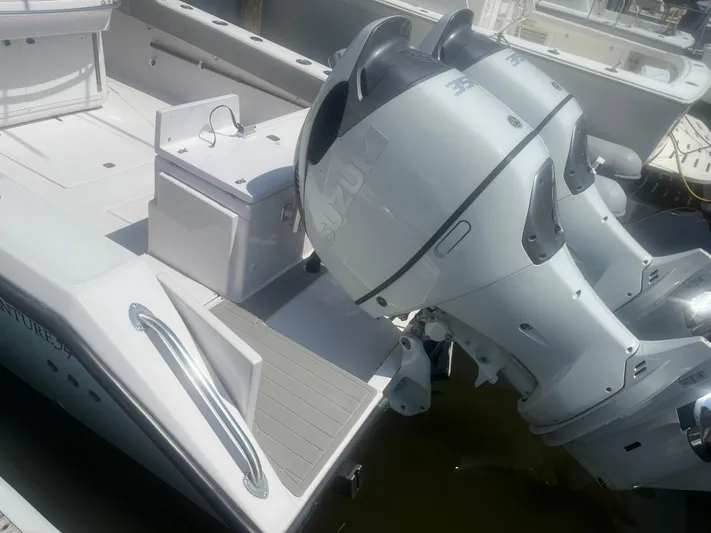  Yacht Photos Pics 2009 Venture 34 CC boat with dual Suzuki outboard engines, docked in a marina.