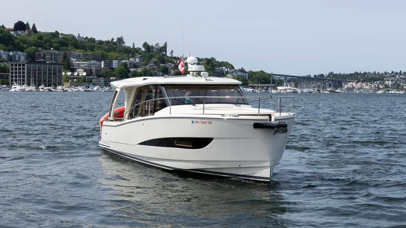 Pastiche Yacht Photos Pics 2019 Greenline Hybrid boat cruising on a scenic lake with cityscape background.