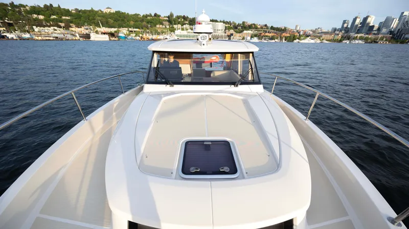 Pastiche Yacht Photos Pics 2019 Greenline Hybrid boat on water with cityscape and greenery in the background.