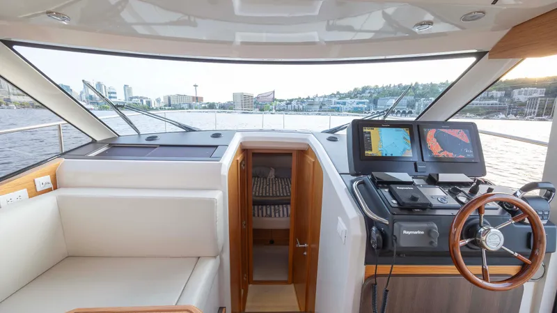 Pastiche Yacht Photos Pics 2019 Greenline Hybrid yacht cockpit with navigation screens and cityscape view.