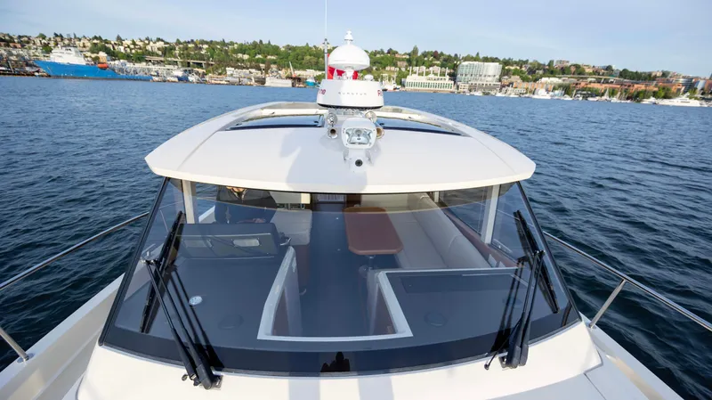 Pastiche Yacht Photos Pics 2019 Greenline Hybrid yacht on calm water with cityscape in the background.