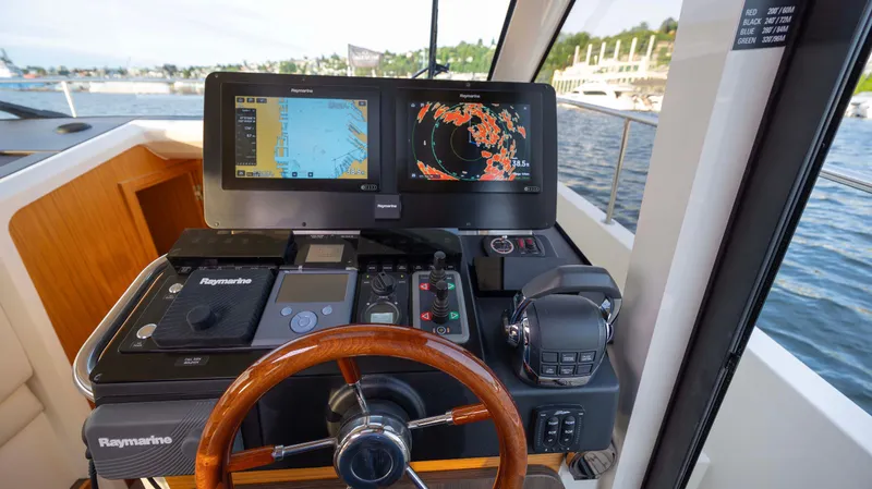 Pastiche Yacht Photos Pics 2019 Greenline Hybrid yacht helm with navigation screens and wooden steering wheel.