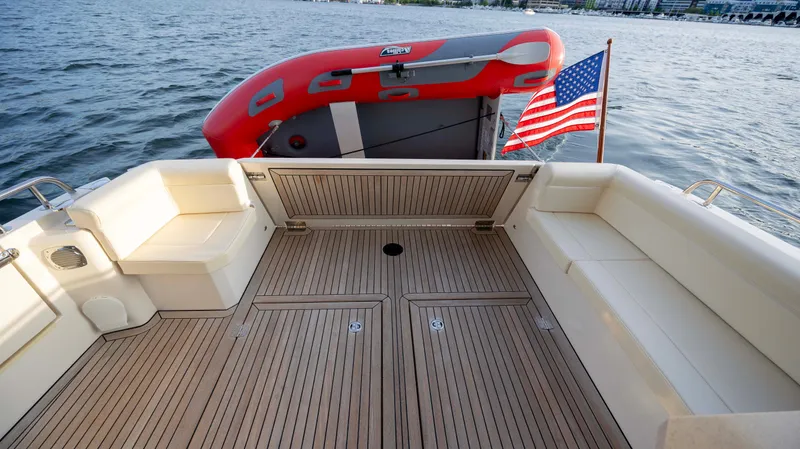 Pastiche Yacht Photos Pics 2019 Greenline Hybrid boat deck with American flag and inflatable boat on water.