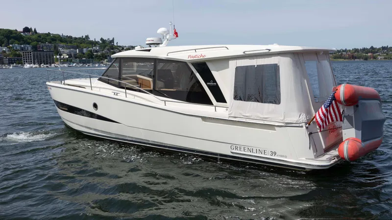 Pastiche Yacht Photos Pics 2019 Greenline Hybrid boat cruising on a lake with American flag and scenic background.