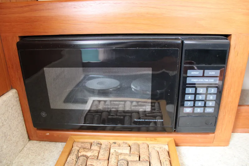 Irish Luck Yacht Photos Pics Built-in microwave in 2002 Mainship Pilot 34 boat kitchen, with cork collection below.