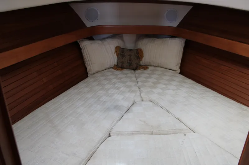 Irish Luck Yacht Photos Pics Cozy cabin interior of 2002 Mainship Pilot 34 with comfortable bedding and wooden accents.