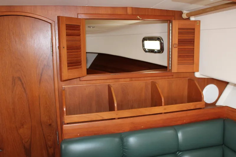 Irish Luck Yacht Photos Pics Interior of 2002 Mainship Pilot 34 with wooden cabinetry and green seating.