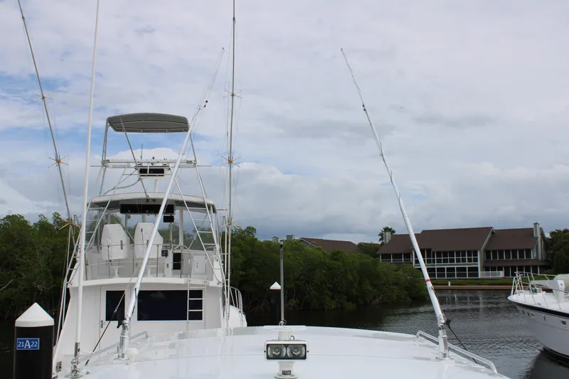 Irish Luck Yacht Photos Pics 2002 Mainship Pilot 34 docked near waterfront buildings and lush greenery.
