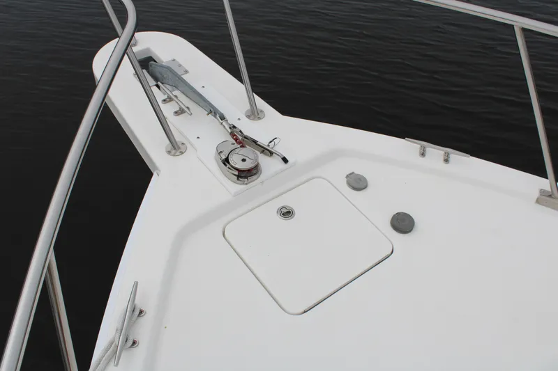 Irish Luck Yacht Photos Pics Bow of 2002 Mainship Pilot 34 with anchor and railing, on calm water.