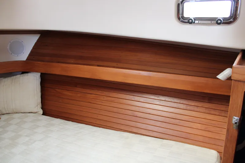 Irish Luck Yacht Photos Pics Cozy cabin interior of 2002 Mainship Pilot 34 with wooden paneling and bedding.