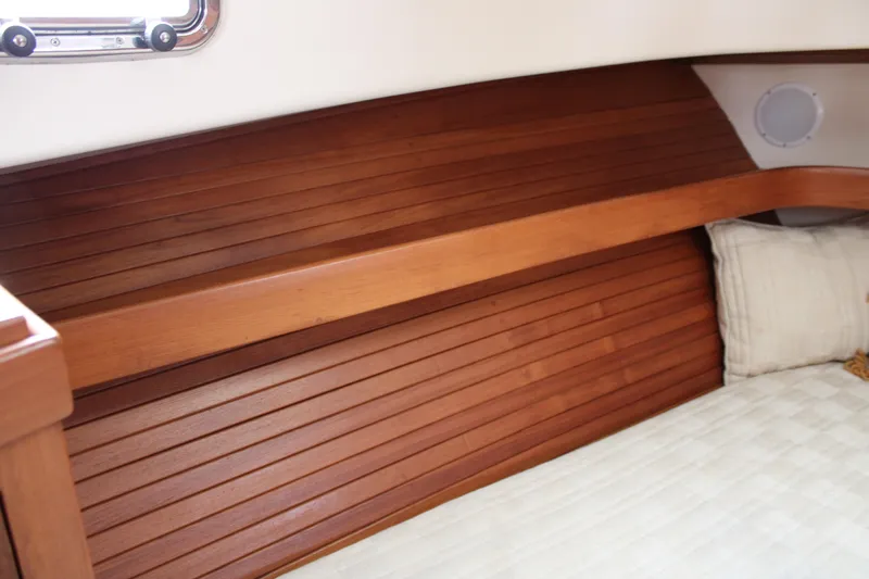 Irish Luck Yacht Photos Pics Interior of 2002 Mainship Pilot 34 boat with wooden paneling and bedding.