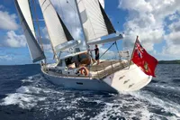 Sailing yacht Amel 64, 2012 model, cruising on open sea under clear skies.