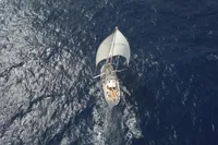 Aerial view of 2012 Amel 64 sailboat navigating open ocean waters.